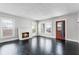 Cozy living room featuring a charming white brick fireplace, natural light, and rich dark hardwood floors at 25 E Pinecrest Ave, Eustis, FL 32726