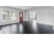 Spacious living room with original dark floors, white trim, arched doorway, and lots of light at 25 E Pinecrest Ave, Eustis, FL 32726