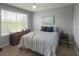 Bright bedroom with a window, dresser, side table, and a bed with blue pillows and striped bedding at 2550 Alafaya Trl # 9303, Orlando, FL 32826