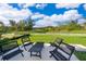 Relaxing backyard patio area with outdoor seating overlooking serene green space at 2596 Penguin Blvd, Davenport, FL 33837