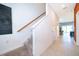 Hallway with tiled floors, stairs with carpet, and a door leading into the dining room and kitchen at 2596 Penguin Blvd, Davenport, FL 33837