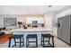 Bright, modern kitchen showcasing an island, stainless steel appliances, and bar stool seating at 2596 Penguin Blvd, Davenport, FL 33837