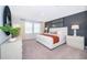 Main bedroom with large window, neutral walls, grey accent wall, and elegant decor at 2596 Penguin Blvd, Davenport, FL 33837
