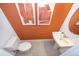 Stylish powder room featuring an orange accent wall, contemporary sink, and modern fixtures at 2596 Penguin Blvd, Davenport, FL 33837