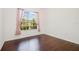 Cozy bedroom boasts hardwood floors, a large window with pink curtains, and ample natural light at 2905 Elbert Way, Kissimmee, FL 34758