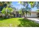 Inviting home with a green lawn, palm trees, and a two-car garage, offering a blend of comfort and style at 2905 Elbert Way, Kissimmee, FL 34758