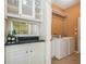 Convenient laundry room with a built-in bar, modern washer and dryer, and storage space at 2905 Elbert Way, Kissimmee, FL 34758