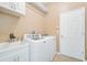 Bright laundry room features a sink, cabinets, and modern, front-loading washer and dryer at 2905 Elbert Way, Kissimmee, FL 34758