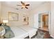 Staged main bedroom with hardwood floors, ceiling fan, and access to the ensuite bathroom and laundry room at 2905 Elbert Way, Kissimmee, FL 34758