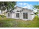 Backyard view of the home, with a well-manicured lawn and slider access to the home at 2978 Stillwater Dr, Kissimmee, FL 34743