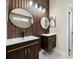Modern bathroom features double sinks with dark wood cabinets, stylish lighting, and wood paneled walls at 2978 Stillwater Dr, Kissimmee, FL 34743