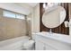 Bright bathroom with wood paneled walls featuring a shower and bathtub combination and large mirror at 2978 Stillwater Dr, Kissimmee, FL 34743