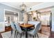 Open-concept dining area showcasing modern light fixture, wood table and sight lines into the kitchen at 3 W Yale St, Orlando, FL 32804