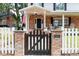 Inviting front gate with brick columns, lantern lighting, and an American flag on the charming front porch at 3 W Yale St, Orlando, FL 32804
