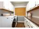Practical laundry room with granite countertops, white cabinets, and modern appliances at 3 W Yale St, Orlando, FL 32804