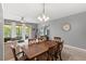 Open-concept dining area with a large dining table, gray walls, and a sliding glass door to the outside at 3055 Ashland N Ln, Kissimmee, FL 34741