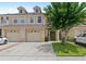 Inviting townhome featuring a well-maintained lawn, two-car garage, and charming architectural details at 3055 Ashland N Ln, Kissimmee, FL 34741