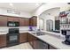 Well-equipped kitchen featuring dark cabinetry, modern appliances, and a seamless countertop at 3055 Ashland N Ln, Kissimmee, FL 34741