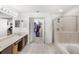 Spacious main bathroom featuring dual sinks, a soaking tub, and a glass-enclosed shower at 3055 Ashland N Ln, Kissimmee, FL 34741