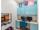 Bright office space featuring a built-in desk, blue cabinets, dual monitors, and colorful decor at 3055 Ashland N Ln, Kissimmee, FL 34741