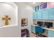 Bright office space featuring a built-in desk, blue cabinets, dual monitors, and colorful decor at 3055 Ashland N Ln, Kissimmee, FL 34741