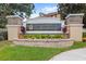 Community sign for Townhomes of Flora Ridge, landscaped with flowers and greenery at 3055 Ashland N Ln, Kissimmee, FL 34741