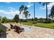 Landscaped backyard features a brick patio area and lush green grass with shade trees and garden at 3404 Shallow Cove Ln, Clermont, FL 34711