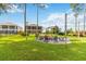 Green backyard with a brick-paved path, lawn, landscaping, fire pit and view of screened patios at 3404 Shallow Cove Ln, Clermont, FL 34711