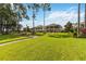 Lush green backyard featuring a brick-paved walkway, manicured lawn, and view of a home at 3404 Shallow Cove Ln, Clermont, FL 34711