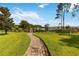 Well-maintained backyard with a brick-paved path leading to a scenic water view at 3404 Shallow Cove Ln, Clermont, FL 34711