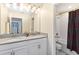 Bathroom featuring dual sinks, and a shower/tub combo with dark curtain at 3404 Shallow Cove Ln, Clermont, FL 34711