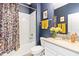 Bathroom with navy walls, a floral shower curtain, and a white vanity at 3404 Shallow Cove Ln, Clermont, FL 34711