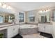 Bright bathroom featuring a large soaking tub, dual vanities, and tiled floors at 3404 Shallow Cove Ln, Clermont, FL 34711