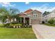 Charming two-story home featuring a well-manicured lawn, lush landscaping, and a welcoming front porch at 3404 Shallow Cove Ln, Clermont, FL 34711