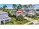 An aerial view of a two-story home with solar panels, mature landscaping, and a lake view at 3404 Shallow Cove Ln, Clermont, FL 34711