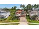 An aerial view of a two-story home with a brick driveway, well-manicured lawn, and mature landscaping at 3404 Shallow Cove Ln, Clermont, FL 34711