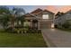 Charming two-story home featuring a well-manicured lawn, lush landscaping, and a welcoming front porch at 3404 Shallow Cove Ln, Clermont, FL 34711