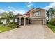 Charming two-story home featuring a well-manicured lawn, lush landscaping, and a welcoming front porch at 3404 Shallow Cove Ln, Clermont, FL 34711