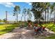 Brick-paved backyard fire pit area with Adirondack chairs and green landscaping overlooking the lake at 3404 Shallow Cove Ln, Clermont, FL 34711