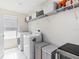Bright laundry room equipped with modern washer, dryer, and storage shelves at 3404 Shallow Cove Ln, Clermont, FL 34711