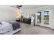 Sunlit main bedroom with a walkout balcony, dresser, and large bed at 3404 Shallow Cove Ln, Clermont, FL 34711