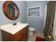 Bathroom includes vanity, toilet, and shower with a decorative framed mirror at 3501 Amigos Ave, Orlando, FL 32808