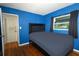 Bedroom featuring a dark plush bed, hardwood floors, and a bright window at 3501 Amigos Ave, Orlando, FL 32808