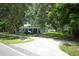Front exterior of a home with a long driveway and mature trees at 3501 Amigos Ave, Orlando, FL 32808