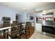 Modern eat-in kitchen has stainless steel appliances, white cabinets, and an open layout to living area at 3501 Amigos Ave, Orlando, FL 32808