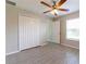 Bright bedroom featuring tile floors, ceiling fan, closet and a window that let's in natural light at 428 Danube Way, Kissimmee, FL 34759
