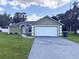 Front exterior of home featuring a garage, manicured lawn, and blue sky at 431 Eagle Dr, Poinciana, FL 34759