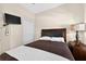Bedroom featuring a queen-sized bed, nightstand and a mounted television at 4558 Baleno Ln, Kissimmee, FL 34746