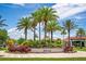Landscaped entrance to Bella Vida features lush palm trees and colorful foliage, creating a welcoming tropical setting at 4558 Baleno Ln, Kissimmee, FL 34746