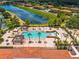 Aerial shot of a large community pool surrounded by lush landscaping and lounge chairs at 4558 Baleno Ln, Kissimmee, FL 34746